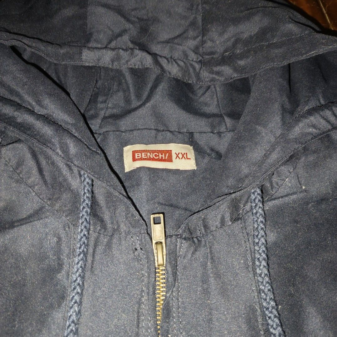Bench Navy Blue Hooded Jacket Size XXL (Category: Coats, Jackets and Outerwear) located in Manila. Submitted by ekko_0xx (Listing ID 1465885228, Image 2). Description: - Brand: Bench - Color: Dark blue - Size: XXL - Design: Full zip front, adjustable hood and hem drawstrings, large 'EST. 87' white chest lettering - Pockets: Two front pockets with button flaps - Condition/Style: Casual outerwear, great for everyday wear or layering.