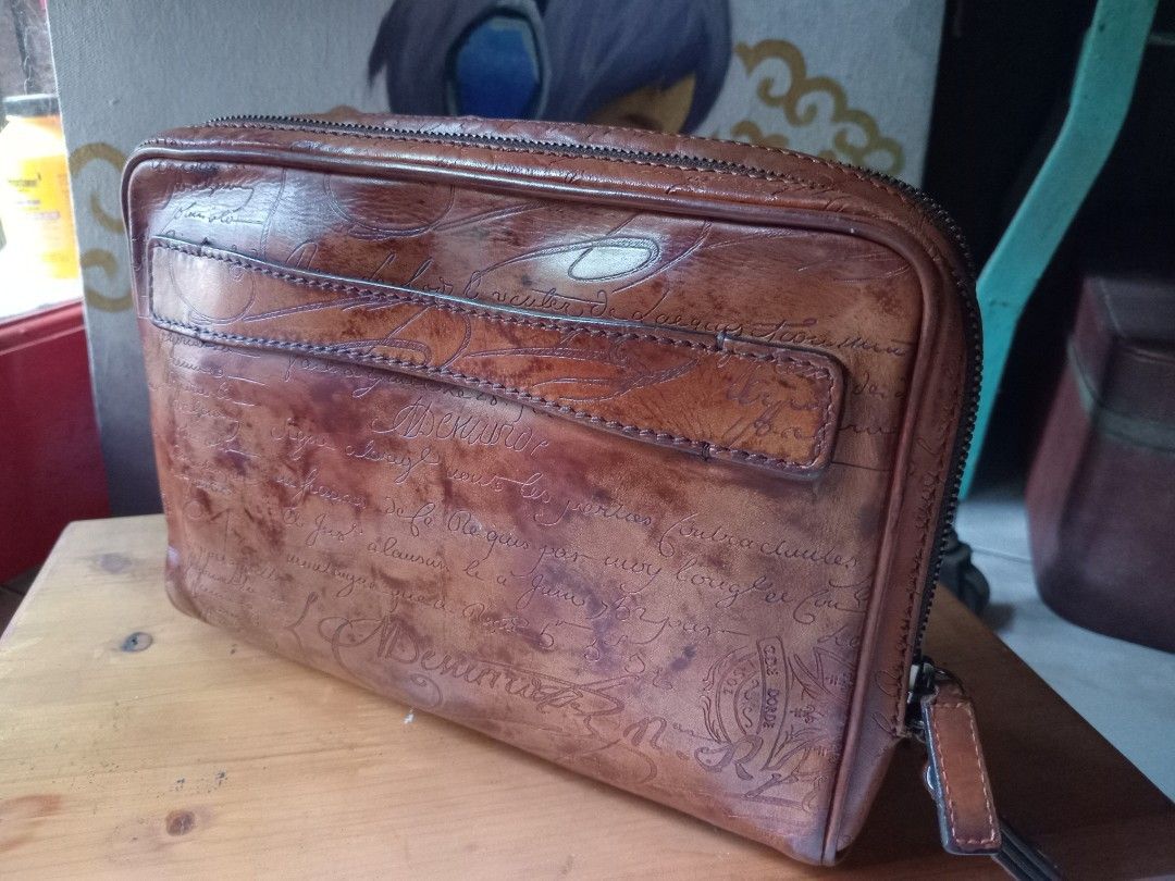 BerlutiBrown Leather Calligraphy Print Zip Pouch (Category: Luxury Bags & Wallets) located in Cagayan de Oro. Submitted by joven.uy86-31596 (Listing ID 1465844864, Image 2). Description: - Material: Brown leather with rich patina and classic structured shape - Design: All-over debossed calligraphy script and vintage stamp motifs - Closure: Zip-around with leather pull tabs - Storage: Front slip pocket and main compartment for cards, cash, and sma