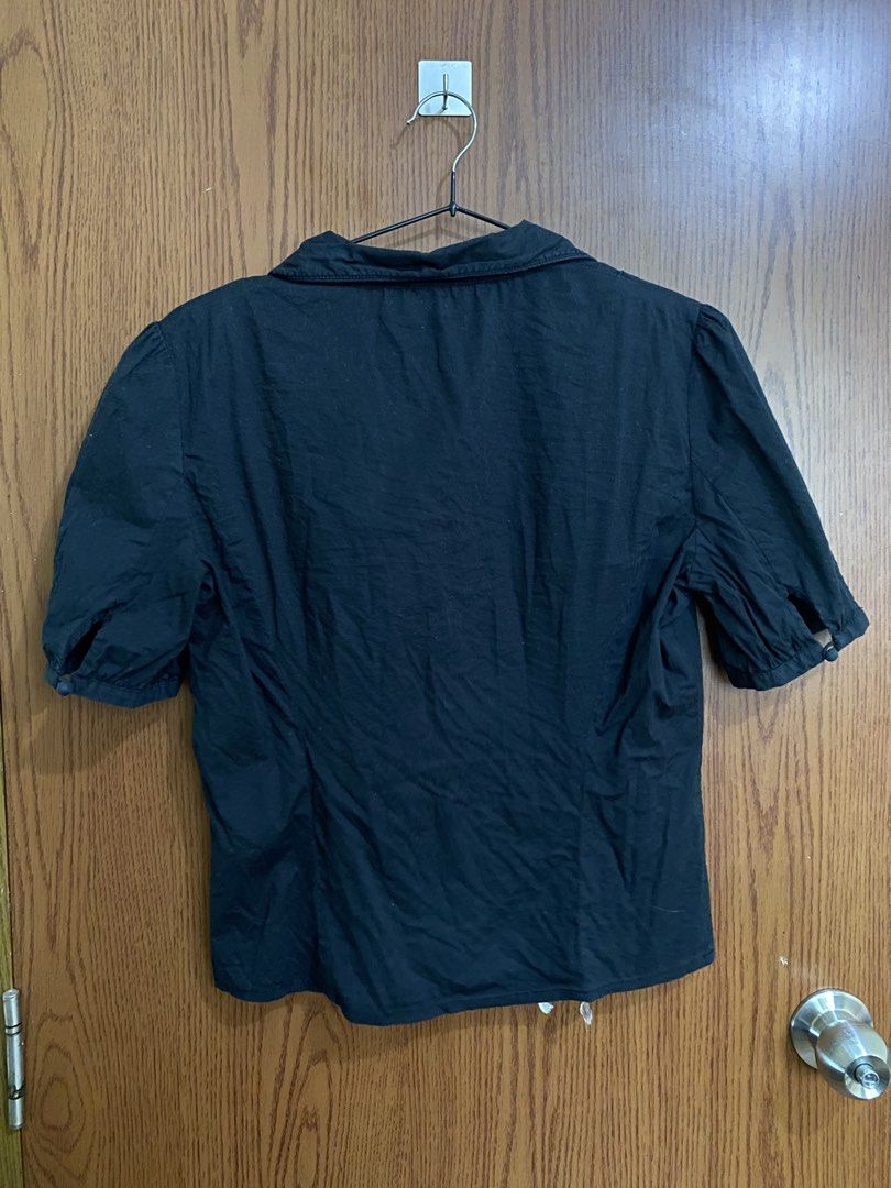 BETU Black Button-Down Short Sleeve Blouse Size L (Category: Blouses) located in Manila. Submitted by anneeem (Listing ID 1465784506, Image 3). Description: - Brand: BETU - Color: Black - Size L on Tag, recommended for Size Medium only - Design: Classic collar, front button fastening, unique curved yoke seam, and vertical waist pleating - Sleeves: Puffed short sleeves with button cuffs - Style: Versatile basic for casual wear or office styling.