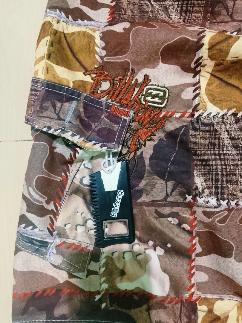 Billabong Patchwork Camo Boardshorts Size 33 (Category: Swim Trunks & Board Shorts) located in Munoz. Submitted by rogelioarq16817 (Listing ID 1465896710, Image 2). Description: Billabong boardshorts in a multi-color camo patchwork design. Orange drawstring waist with branded eyelets. Side cargo pocket with an attached wax comb bottle opener. 100% polyester material, style number M1015VAG. Size 33 tag inside. width 33/36 fit length 23 leg opening
