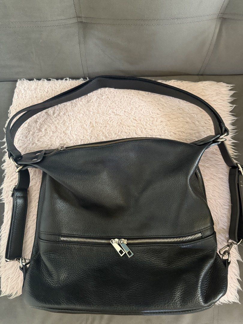 Black leather slouchy shoulder bag with front zip pocket (Category: Shoulder Bags) located in Malolos. Submitted by gb_21895 (Listing ID 1465951401, Image 1). Description: - Material: Premium black textured leather in clean condition with zero scuffs or tears - Compartments: Roomy main compartment with a secure zip top closure - Pockets: Exterior zip pocket with double silver pull tabs, plus interior slip and zippered pockets - Strap: Adjustable 