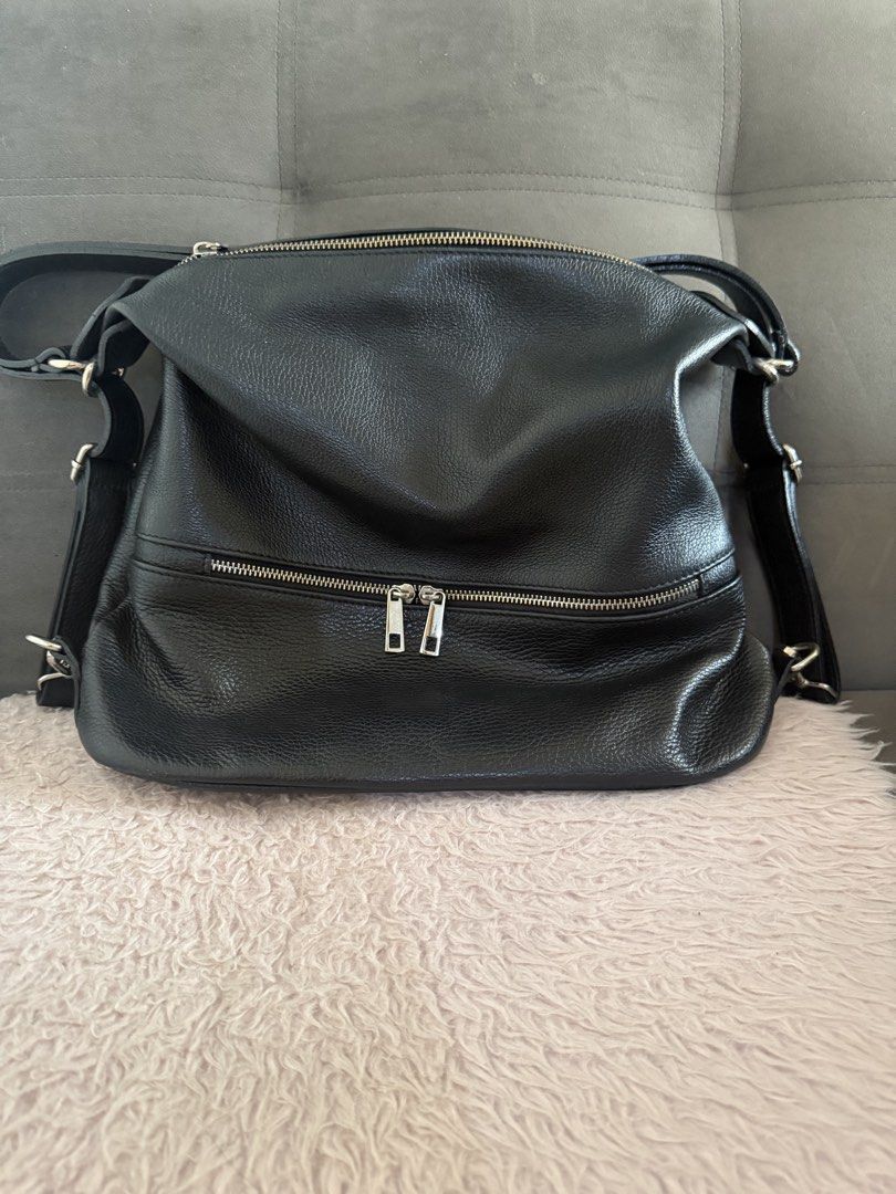Black leather slouchy shoulder bag with front zip pocket (Category: Shoulder Bags) located in Malolos. Submitted by gb_21895 (Listing ID 1465951401, Image 3). Description: - Material: Premium black textured leather in clean condition with zero scuffs or tears - Compartments: Roomy main compartment with a secure zip top closure - Pockets: Exterior zip pocket with double silver pull tabs, plus interior slip and zippered pockets - Strap: Adjustable 