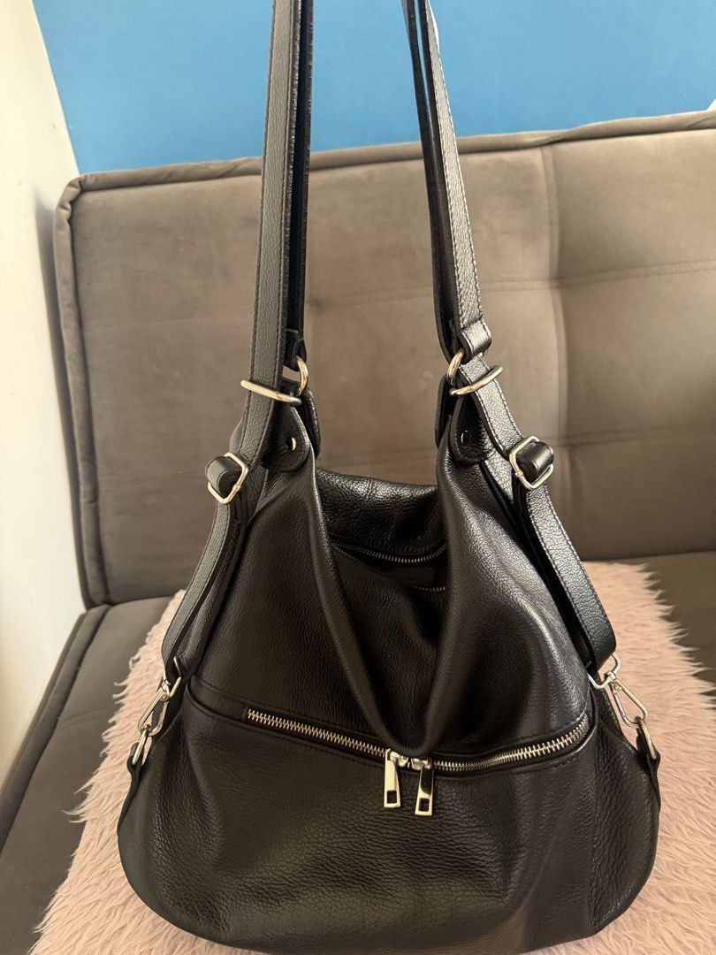 Black leather slouchy shoulder bag with front zip pocket (Category: Shoulder Bags) located in Malolos. Submitted by gb_21895 (Listing ID 1465951401, Image 2). Description: - Material: Premium black textured leather in clean condition with zero scuffs or tears - Compartments: Roomy main compartment with a secure zip top closure - Pockets: Exterior zip pocket with double silver pull tabs, plus interior slip and zippered pockets - Strap: Adjustable 