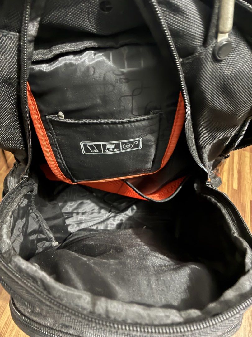 Black Multi-Compartment Tech Backpack (Category: Backpacks) located in Manila. Submitted by jhie24 (Listing ID 1465792092, Image 3). Description: - Color: Sleek black with stylish orange interior accents - Material: Durable textured fabric - Compartments: Multiple zipped compartments inside and out - Laptop Storage: Dedicated padded compartment with a laptop icon tab - Organization: Small internal pocket with icons for phone, media player, and di