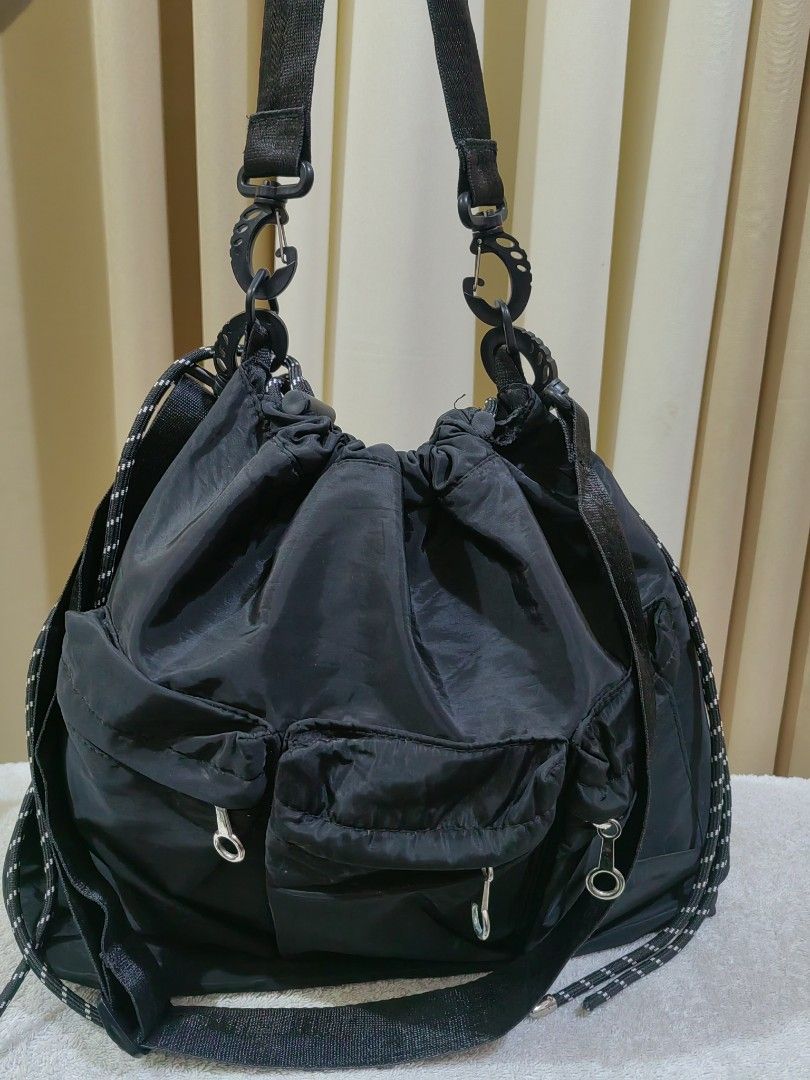 Black Nylon Utility Shoulder Bag with Multiple Pockets (Category: Shoulder Bags) located in Makati City. Submitted by prelovedtreatedwithlove (Listing ID 1465829496, Image 3). Description: Black nylon shoulder bag, roomy interior. Drawstring closure on top. Multiple exterior pockets with ring pull zippers. 2 ways good for daily errands or casual outings. No issue A-240.
