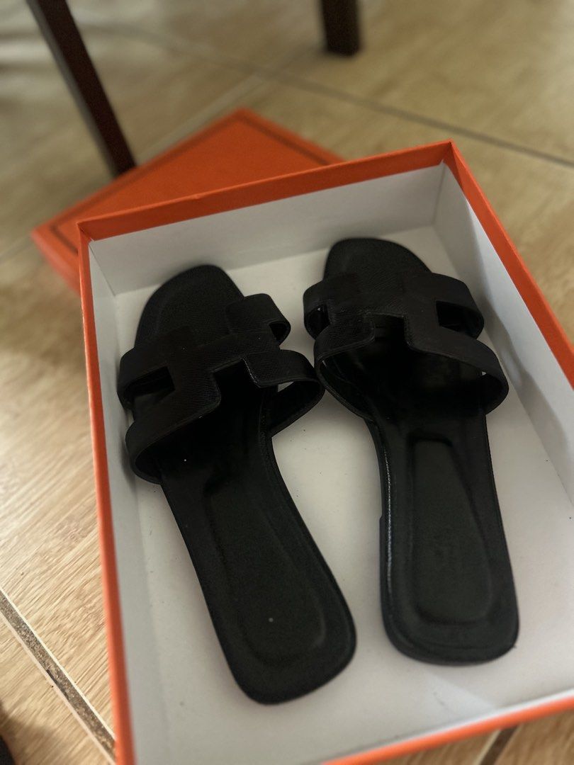 Black Oran Sandals (Category: Flats & Sandals) located in Manila. Submitted by quinfeisty (Listing ID 1465820593, Image 1). Description: - Style: Iconic H-strap slip-on flats - Size: 38 - Material: Premium leather - Condition: Not too worm - Inclusion: orange box .