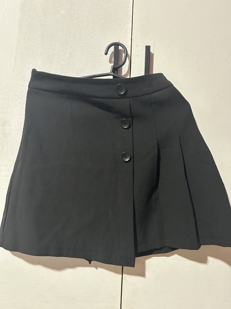 Black Pleated Mini Skirt with Front Buttons (Category: Skirts) located in Manila. Submitted by maeshop2026 (Listing ID 1465842303, Image 1). Description: Size: 27-28 (high waist) Originally sized XL but made fitted to 27-28 (reversible) - Style: Black skirt with asymmetric front overlay - Details: Decorative buttons and pleated right side - Fit: Mid-rise waistband with clean hem - Condition: Excellent, clean, no obvious flaws - Versatility: Easy 