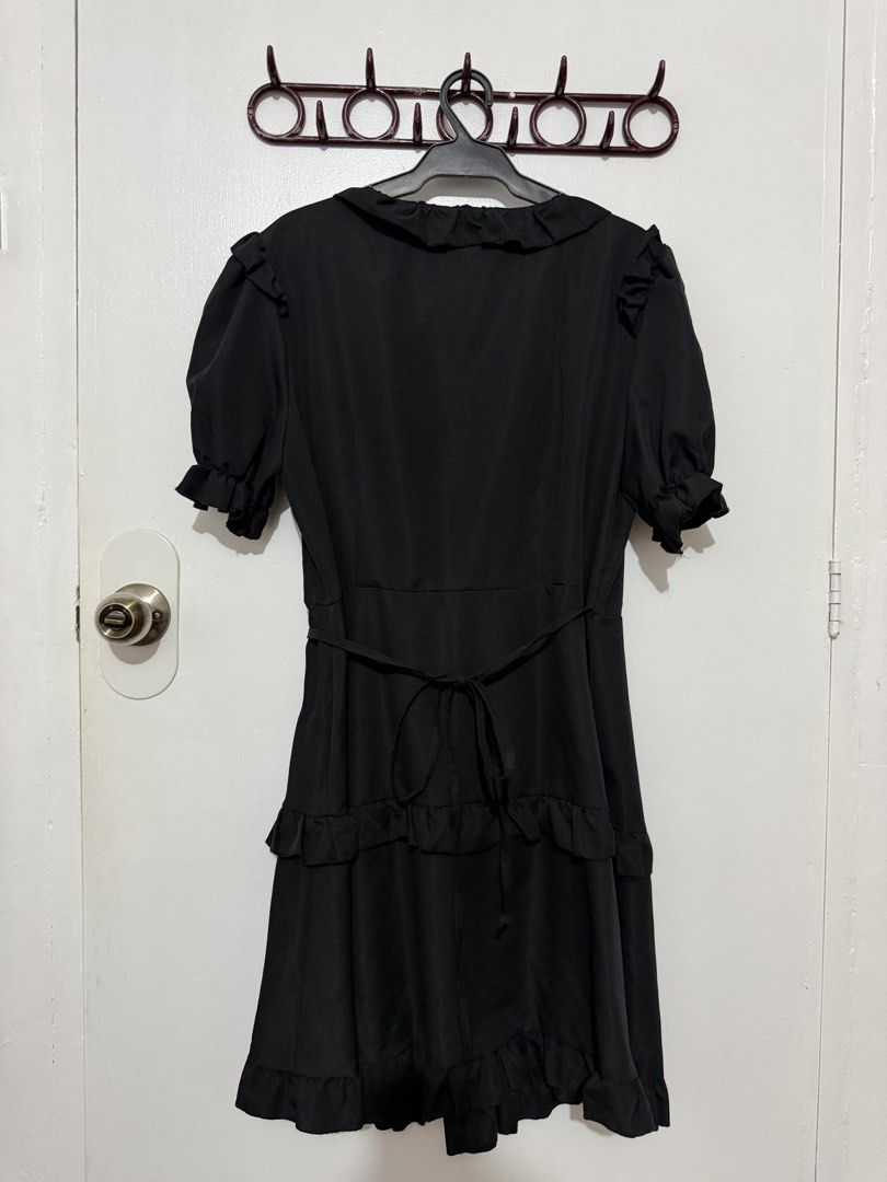 Black V-neck Ruffle Mini Dress with Tie Back (Category: Dresses) located in Las Pinas. Submitted by milkydeclutter (Listing ID 1465937554, Image 2). Description: - Color: Black - Style: Mini dress with short sleeves and flowy shape - Details: Playful ruffles on V-neckline and tiered skirt - Fit: Adjustable tie-back waist for a custom fit - Fabric: Lightweight and comfortable - Occasion: Great for casual outings or dinner dates.