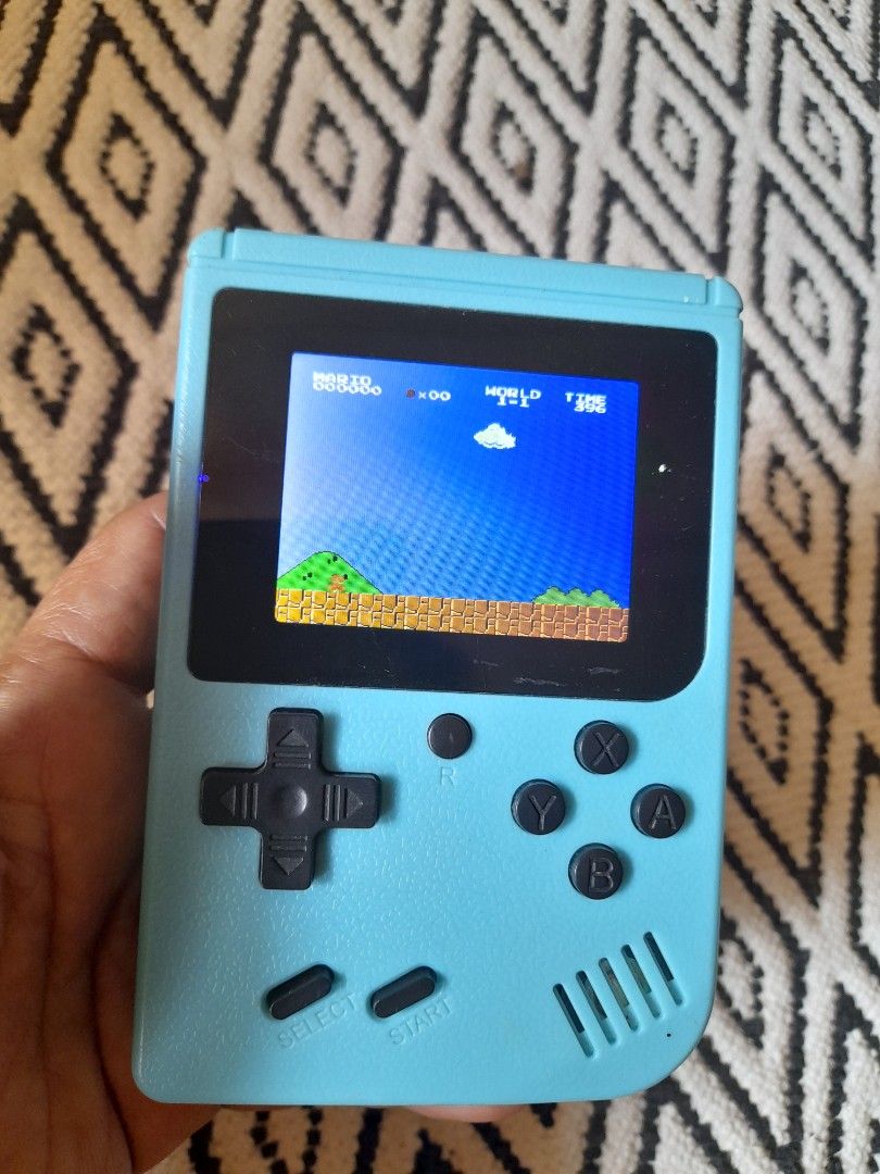 Blue Retro Handheld Gaming Console with Classic Games (Category: Nintendo) located in Bocaue. Submitted by marajapansurplus (Listing ID 1465801309, Image 2). Description: - Color: Light blue - Compact retro design, perfect for gaming on the go - Features a vibrant color screen showing classic space games - Classic control layout: D-pad, four action buttons, start, and select - Built-in speaker on the top right - Battery-powered with a convenient 
