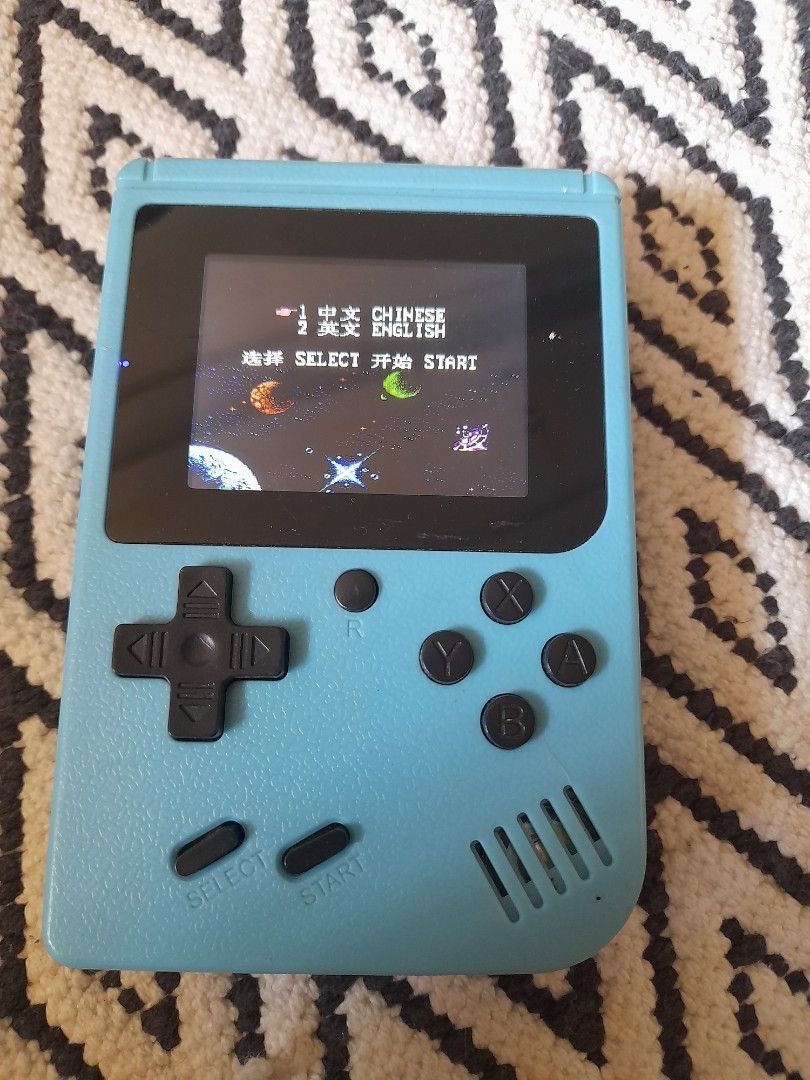 Blue Retro Handheld Gaming Console with Classic Games (Category: Nintendo) located in Bocaue. Submitted by marajapansurplus (Listing ID 1465801309, Image 1). Description: - Color: Light blue - Compact retro design, perfect for gaming on the go - Features a vibrant color screen showing classic space games - Classic control layout: D-pad, four action buttons, start, and select - Built-in speaker on the top right - Battery-powered with a convenient 
