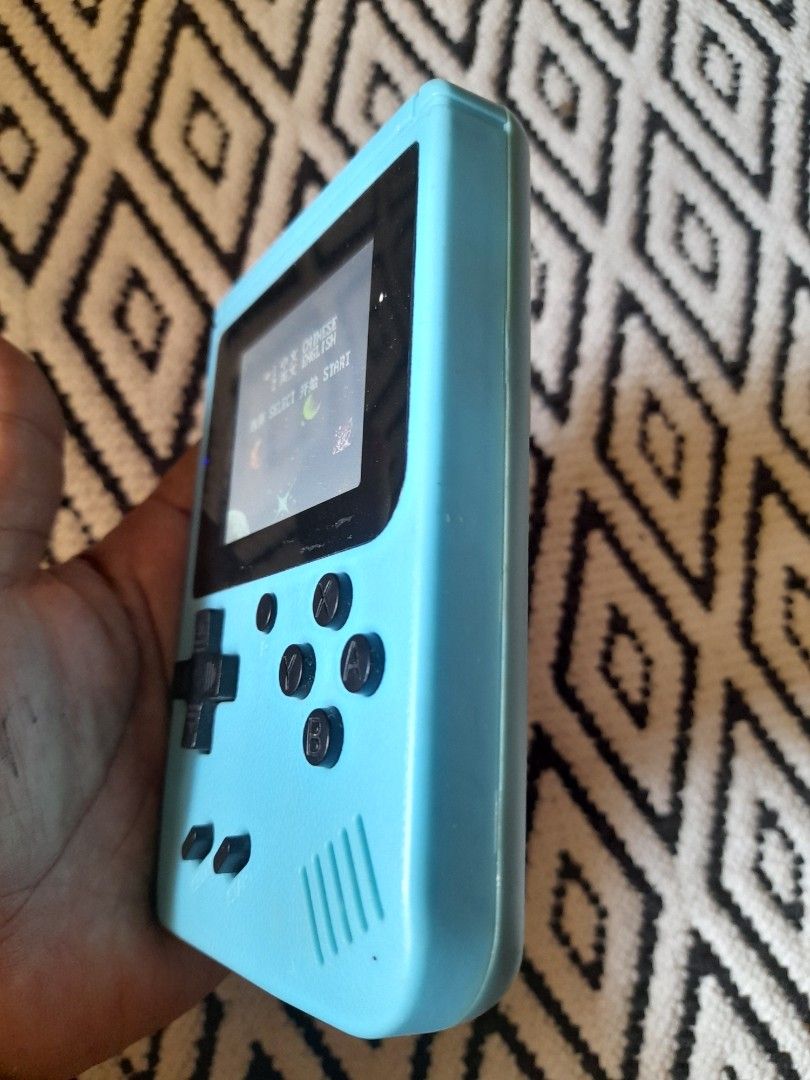 Blue Retro Handheld Gaming Console with Classic Games (Category: Nintendo) located in Bocaue. Submitted by marajapansurplus (Listing ID 1465801309, Image 3). Description: - Color: Light blue - Compact retro design, perfect for gaming on the go - Features a vibrant color screen showing classic space games - Classic control layout: D-pad, four action buttons, start, and select - Built-in speaker on the top right - Battery-powered with a convenient 