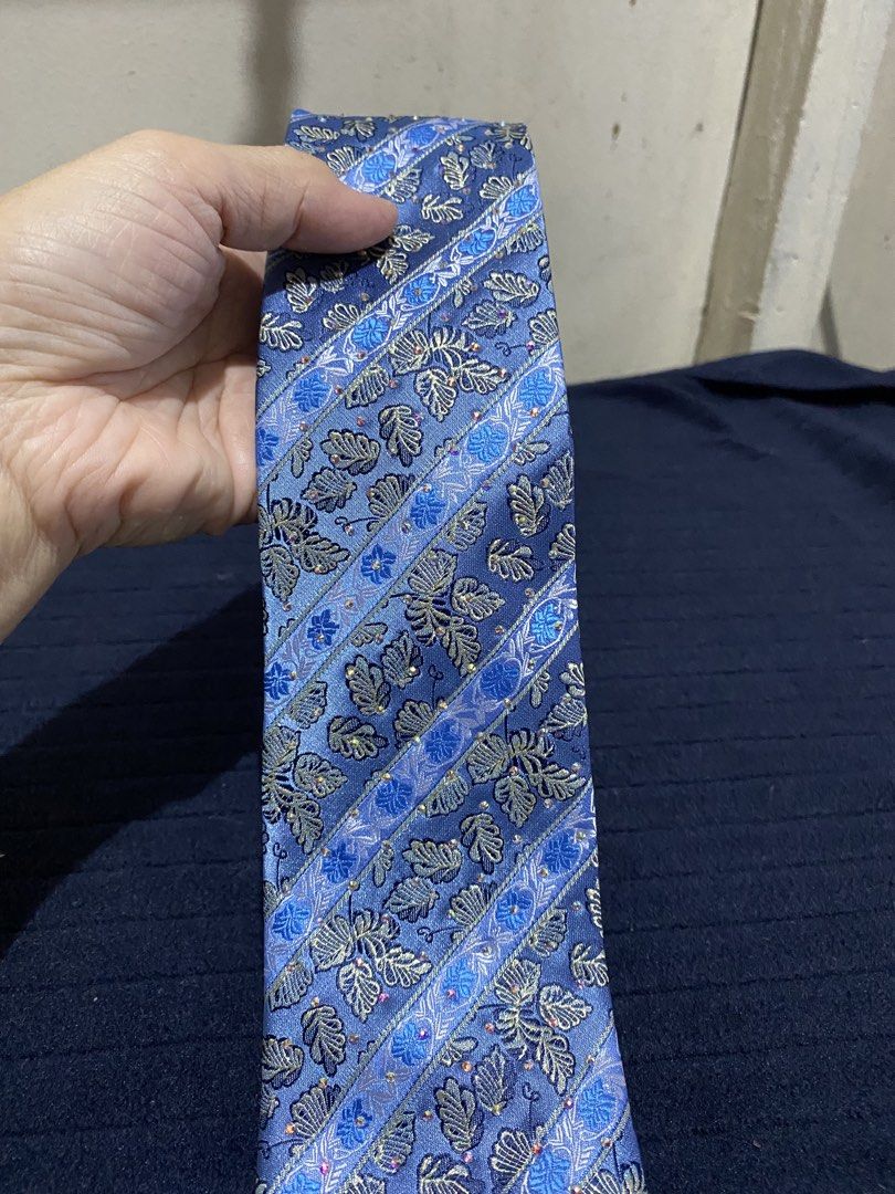 Blue striped floral patterned necktie 100% polyester (Category: Ties) located in Manila. Submitted by resi.diaz (Listing ID 1465893155, Image 2). Description: - Color: Blue with diagonal stripes and leaf floral pattern - Material: 100% polyester - Width: Standard blade - Care: Dry clean only (fabric care tag attached) - Origin: Made in China.