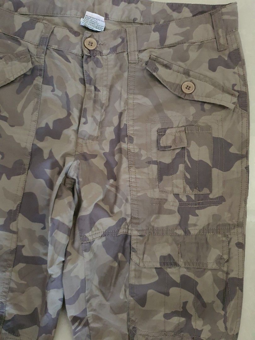 Brown Camouflage Cargo Pants Utility Trousers (Category: Jeans) located in Meycauayan. Submitted by shoptoown (Listing ID 1465811513, Image 2). Description: - Color: Brown and grey camouflage - Fit: Relaxed fit style - Material: Durable cotton fabric - Pockets: Multiple utility pockets on sides and thighs with button flaps - Closure: Button closure at the waist with belt loops - waist 33 inches, lenght 41 inches, leg hole width 9 inches.