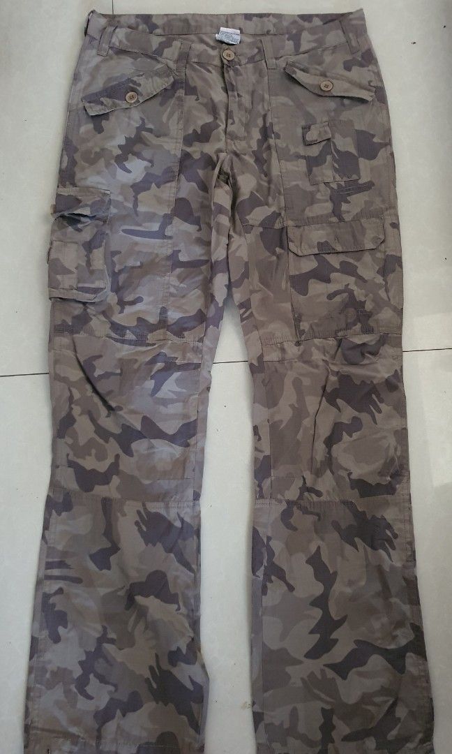 Brown Camouflage Cargo Pants Utility Trousers (Category: Jeans) located in Meycauayan. Submitted by shoptoown (Listing ID 1465811513, Image 1). Description: - Color: Brown and grey camouflage - Fit: Relaxed fit style - Material: Durable cotton fabric - Pockets: Multiple utility pockets on sides and thighs with button flaps - Closure: Button closure at the waist with belt loops - waist 33 inches, lenght 41 inches, leg hole width 9 inches.