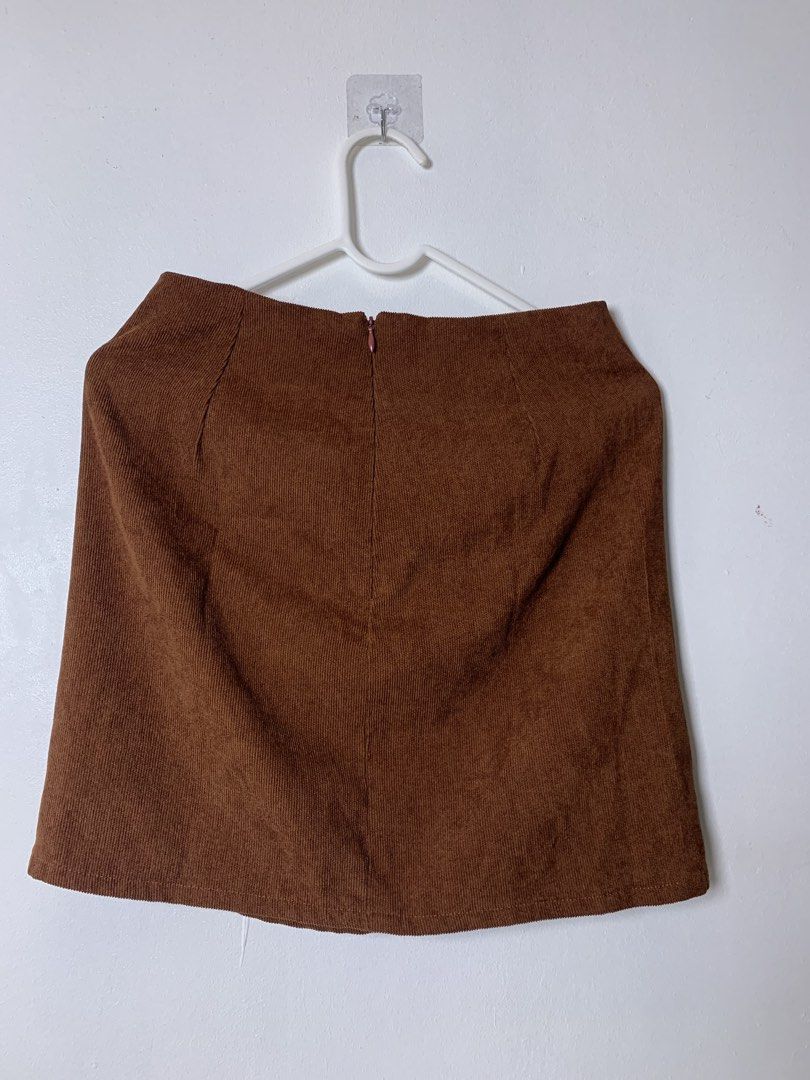 Brown Corduroy Mini Skirt with Front Slit (Category: Skirts) located in San Pedro. Submitted by reginacarla (Listing ID 1465790640, Image 2). Description: - Brown textured corduroy fabric with vertical ridges - Short length with a straight cut and subtle side slit - Hidden back zipper closure for a clean look - Easy to style with tees or sweaters for an autumn-ready outfit.