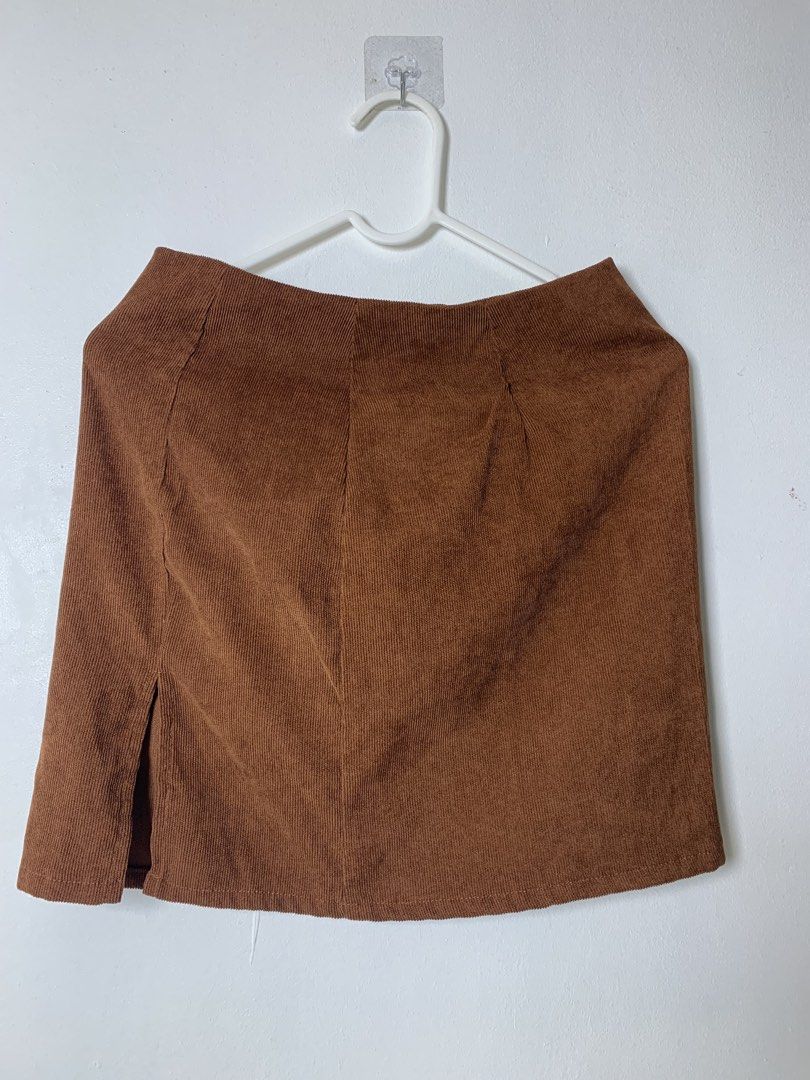 Brown Corduroy Mini Skirt with Front Slit (Category: Skirts) located in San Pedro. Submitted by reginacarla (Listing ID 1465790640, Image 1). Description: - Brown textured corduroy fabric with vertical ridges - Short length with a straight cut and subtle side slit - Hidden back zipper closure for a clean look - Easy to style with tees or sweaters for an autumn-ready outfit.