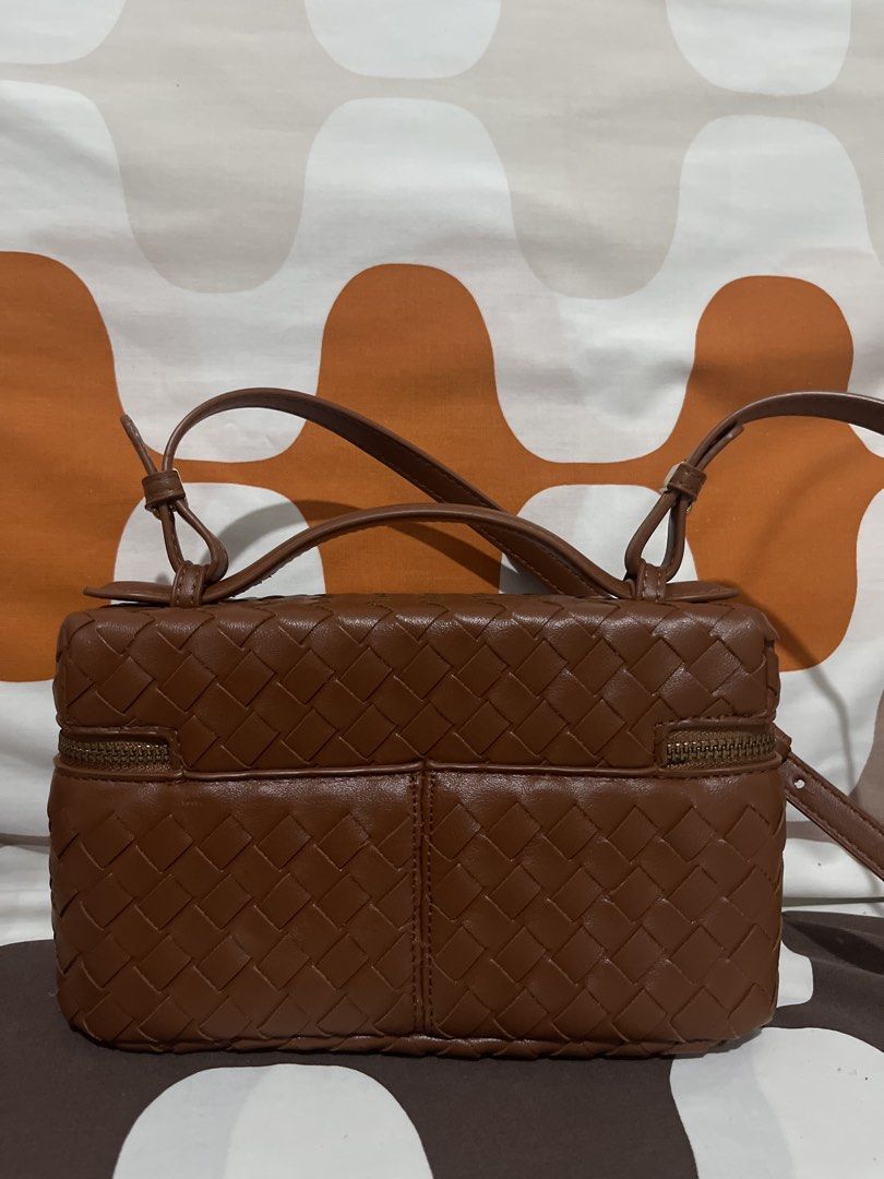 Brown Woven Leather Vanity Bag Crossbody (Category: Cross-body Bags) located in Las Pinas. Submitted by erenrosc (Listing ID 1465893604, Image 2). Description: - Brown faux leather with an all-over woven pattern - Structured boxy shape with gold-toned hardware - Double zipper closure and top handle - Includes an adjustable and detachable crossbody strap - Smooth interior lining with a handy slip pocket - Compact size, perfect for daily essentials