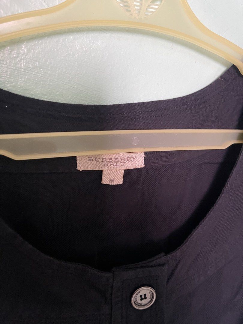Burberry Brit Black Dress Size M (Category: Dresses) located in Baybay. Submitted by shikita27906 (Listing ID 1465845952, Image 3). Description: - Brand: Burberry Brit - Size: Medium - Color: Black with subtle tonal check pattern - Style: Classic fit and flare silhouette - Details: Short cap sleeves, round neckline, engraved button-down front, and two pleated waist pockets with button flaps.