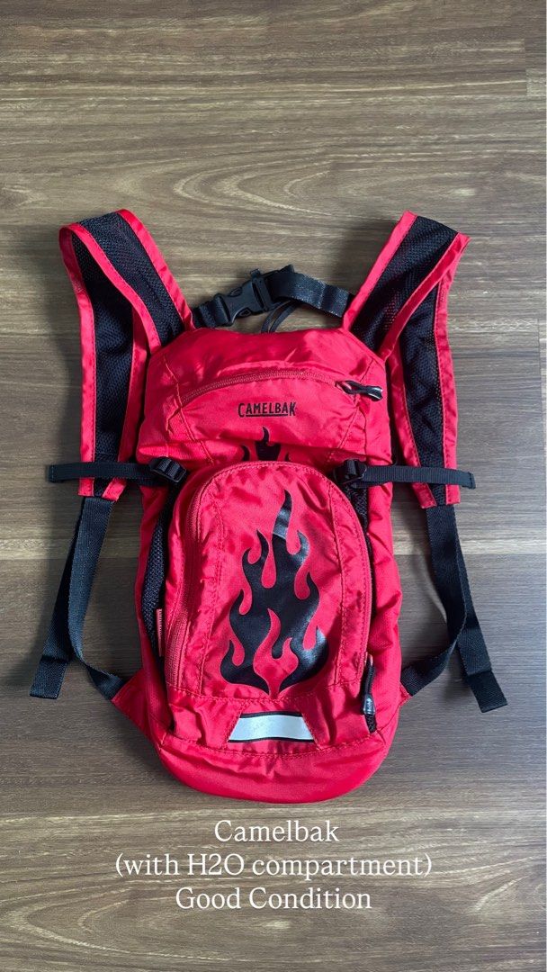 Camelbak Red Hydration Backpack with Flame Design (Category: Backpacks) located in Bacolod City. Submitted by jmcercado (Listing ID 1465925679, Image 1). Description: - Authentic Red Camelbak hydration backpack - Stylish black design with front flame graphic - Breathable mesh shoulder straps with adjustable chest buckle - Built-in dedicated H2O water compartment in the main storage section - Reflective safety strip near the bottom - Clean exterio
