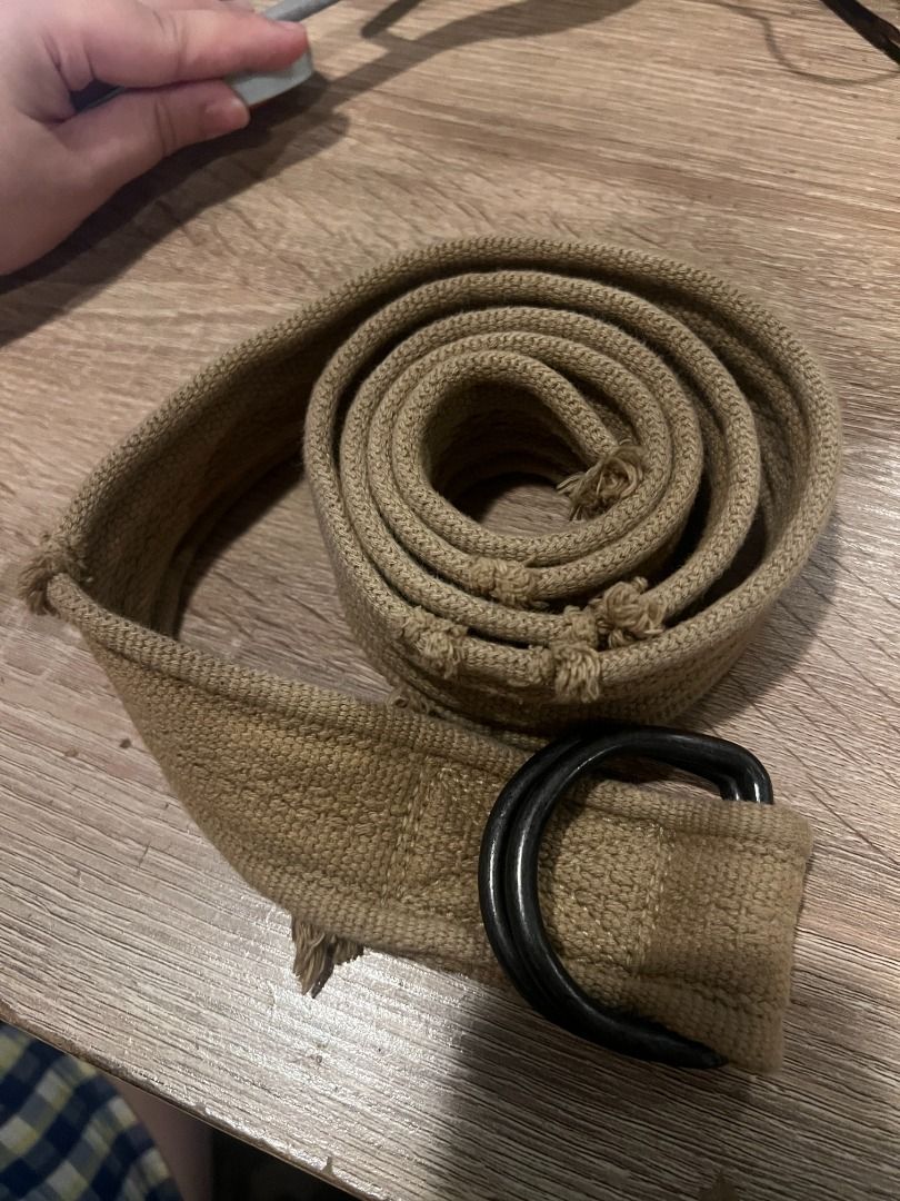 Canvas Belt with Double Ring Buckle [m1] (Category: Belts) located in Pasig City. Submitted by awesamfinds (Listing ID 1465843131, Image 1). Description: - Color/Material: Khaki canvas with textured fabric strap - Hardware: Double black metal rings - Style: Neutral earth tone, perfect for casual pants and shorts - Features: Adjustable length and easy rolled storage L: 125 cm.