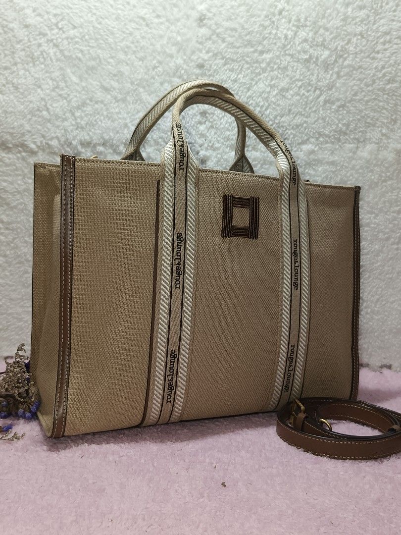 Canvas Tote bag Rouge & lounge (Category: Tote Bags) located in Taguig. Submitted by shop.etherealph (Listing ID 1465894195, Image 2). Description: ‎Brand: ROUGE&LOUNGE ‎Name: Canvas Tote Bag ‎Details: beige canvas tote bag with brown leather trim and webbed handles branded with the Rouge&lounge logo. ‎ ‎Condition: Pre-Loved with Minimal to NO sign of usage. ‎Inclusion: Dust Bag ‎ ‎Disclaimer: We are not affiliated with, sponsored by, or related 