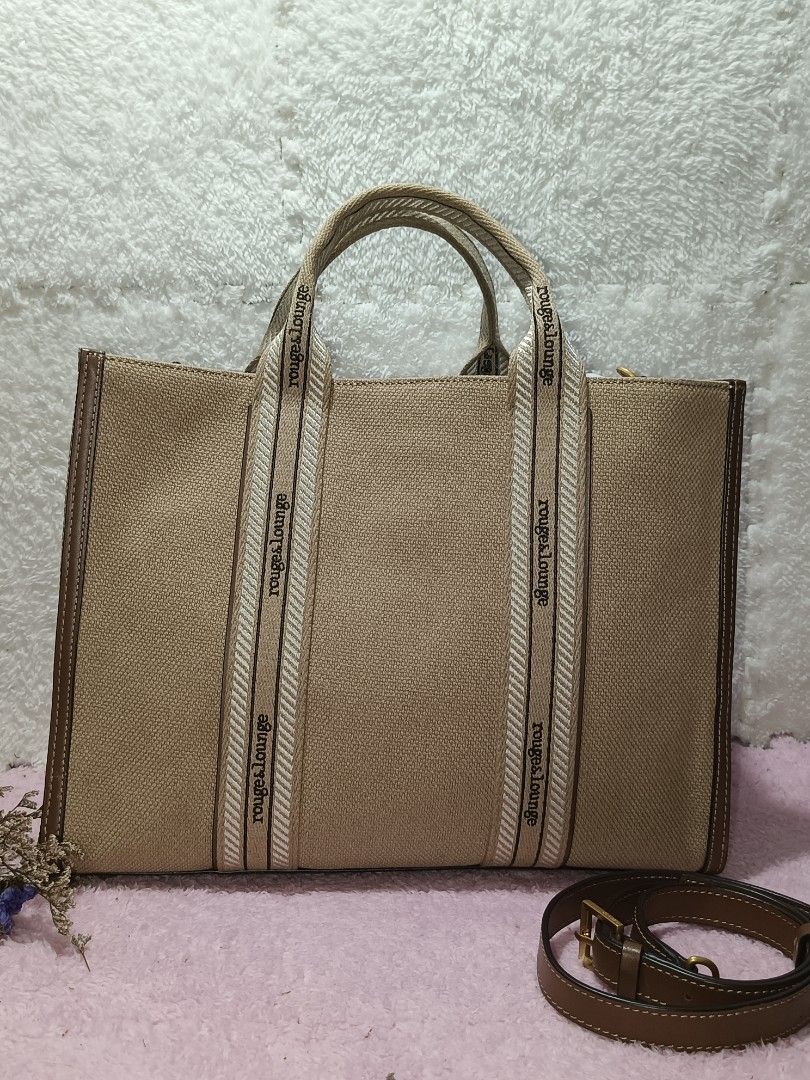Canvas Tote bag Rouge & lounge (Category: Tote Bags) located in Taguig. Submitted by shop.etherealph (Listing ID 1465894195, Image 3). Description: ‎Brand: ROUGE&LOUNGE ‎Name: Canvas Tote Bag ‎Details: beige canvas tote bag with brown leather trim and webbed handles branded with the Rouge&lounge logo. ‎ ‎Condition: Pre-Loved with Minimal to NO sign of usage. ‎Inclusion: Dust Bag ‎ ‎Disclaimer: We are not affiliated with, sponsored by, or related 