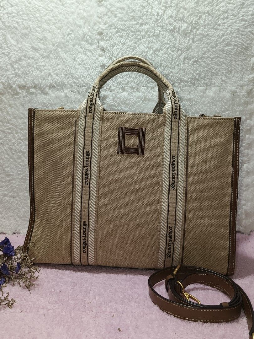 Canvas Tote bag Rouge & lounge (Category: Tote Bags) located in Taguig. Submitted by shop.etherealph (Listing ID 1465894195, Image 1). Description: ‎Brand: ROUGE&LOUNGE ‎Name: Canvas Tote Bag ‎Details: beige canvas tote bag with brown leather trim and webbed handles branded with the Rouge&lounge logo. ‎ ‎Condition: Pre-Loved with Minimal to NO sign of usage. ‎Inclusion: Dust Bag ‎ ‎Disclaimer: We are not affiliated with, sponsored by, or related 