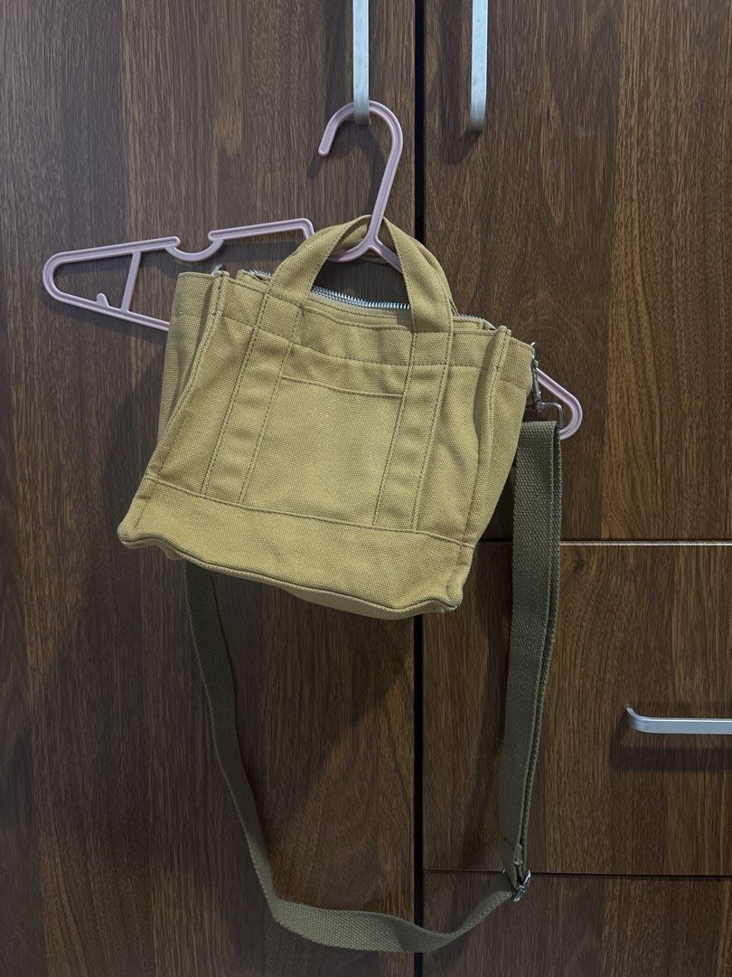 Canvas Tote Bag with Crossbody Strap (Category: Cross-body Bags) located in Paranaque City. Submitted by rosexxxd (Listing ID 1465909296, Image 1). Description: - Color: Mustard yellow - Material: Durable canvas - Closure: Secure top zipper - Pockets: Convenient outside front pocket with vertical stitching - Straps: Double top handles plus a matching adjustable webbed shoulder strap with metal clasps - Used less than 5 times but stored in cabinet