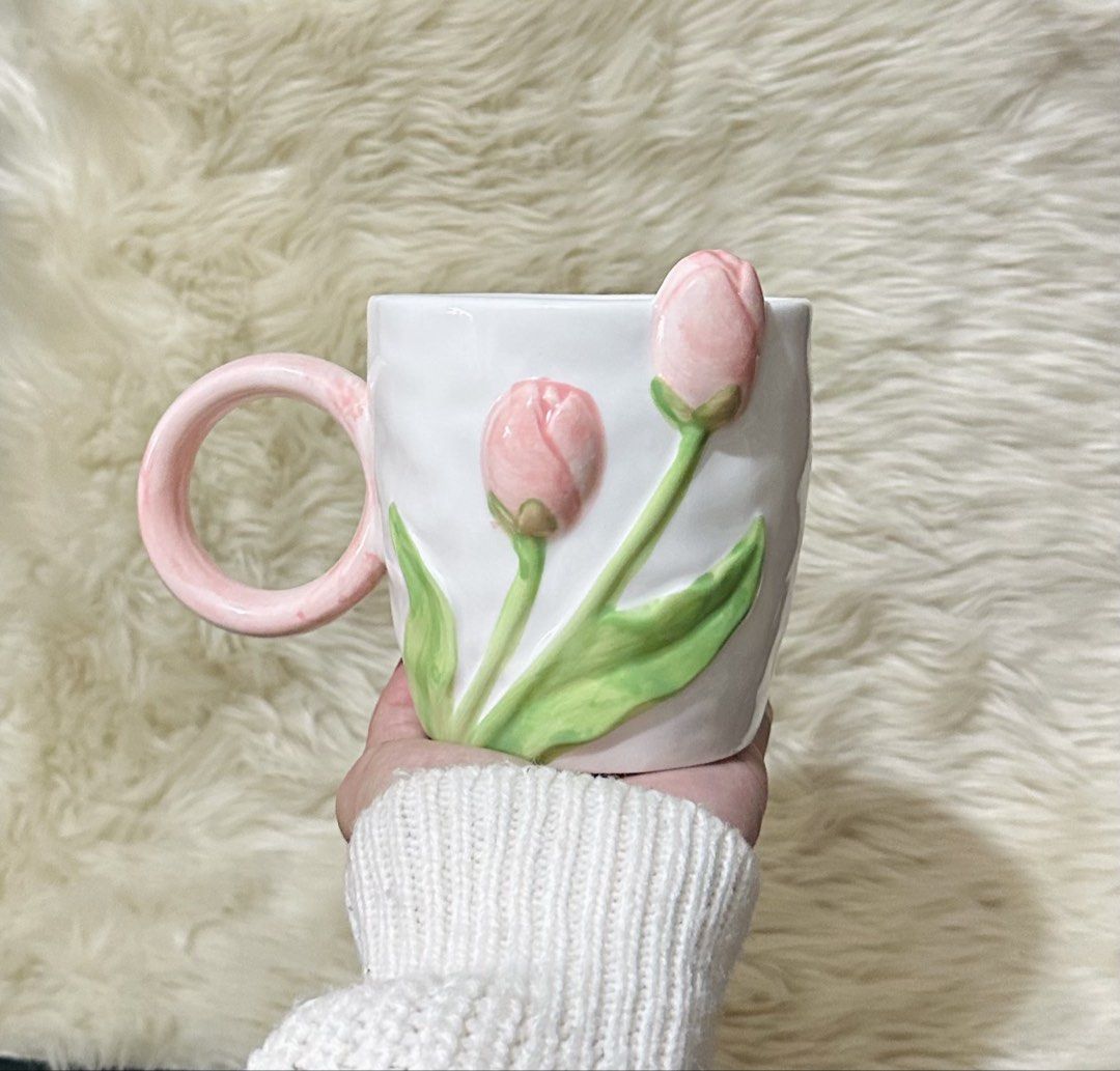 Ceramic Tulip Mug with 3D Pink Flowers (Category: Coffee & Tea Tableware) located in Manila. Submitted by tinayyy_08 (Listing ID 1465932314, Image 1). Description: - Material: High-quality white ceramic - Design: 3D pink tulip flowers with green stems and a round pink handle - Texture: Unique textured surface - Function: Suitable for both hot and cold beverages - Ideal For: Gifting to tulip lovers or enhancing cottagecore room decor.