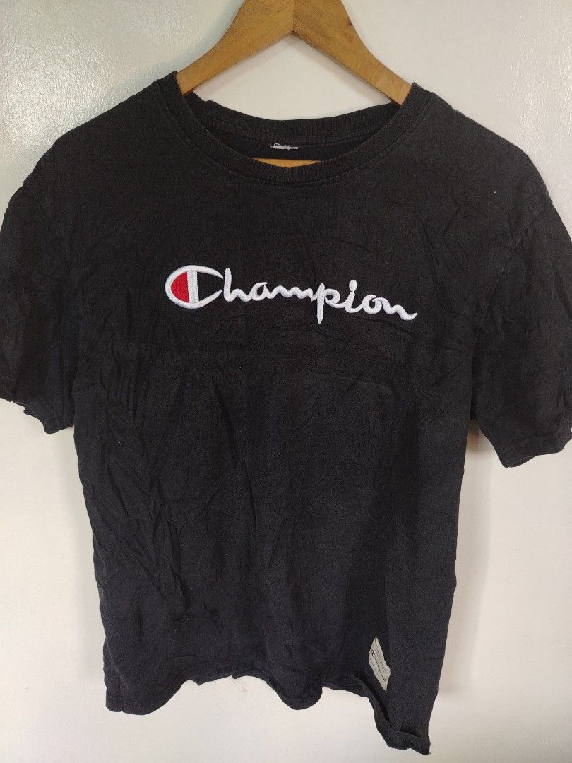 Champion Black Script Logo T-Shirt (Category: Tshirts & Polo Shirts ) located in Manila. Submitted by zyclothing03 (Listing ID 1465828215, Image 2). Description: - Color: Black - Design: Large embroidered Champion script logo on chest, iconic C logo patch on left sleeve - Fit/Style: Classic crew neckline, short sleeves, streetwear staple - Condition: Good pre-loved condition with a slightly worn collar tag - Perfect for daily casual wear and stre