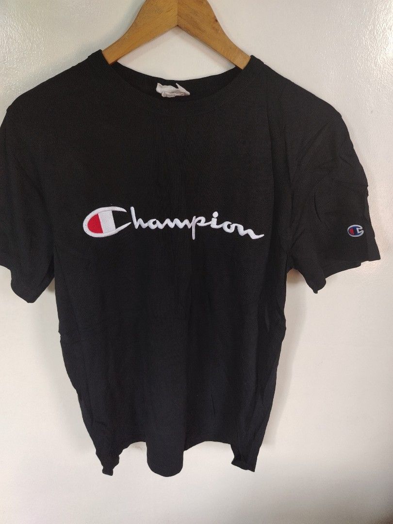 Champion Black Script Logo T-Shirt (Category: Tshirts & Polo Shirts ) located in Manila. Submitted by zyclothing03 (Listing ID 1465828215, Image 1). Description: - Color: Black - Design: Large embroidered Champion script logo on chest, iconic C logo patch on left sleeve - Fit/Style: Classic crew neckline, short sleeves, streetwear staple - Condition: Good pre-loved condition with a slightly worn collar tag - Perfect for daily casual wear and stre