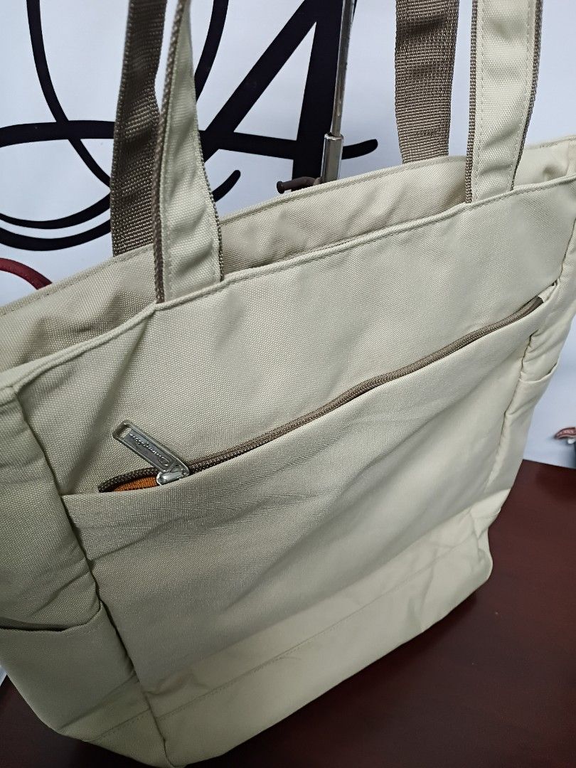 Champion Canvas Tote Bag Beige (Category: Tote Bags) located in Quezon City. Submitted by fateonlineshop (Listing ID 1465797267, Image 3). Description: - Brand: Champion - Color: Beige canvas with a vibrant orange nylon interior - Straps: Sturdy dual shoulder straps for comfortable carrying - Pockets: Large exterior front zip pocket and interior slip pockets for organization - Condition: Clean inside and out, very durable construction - Ideal Use