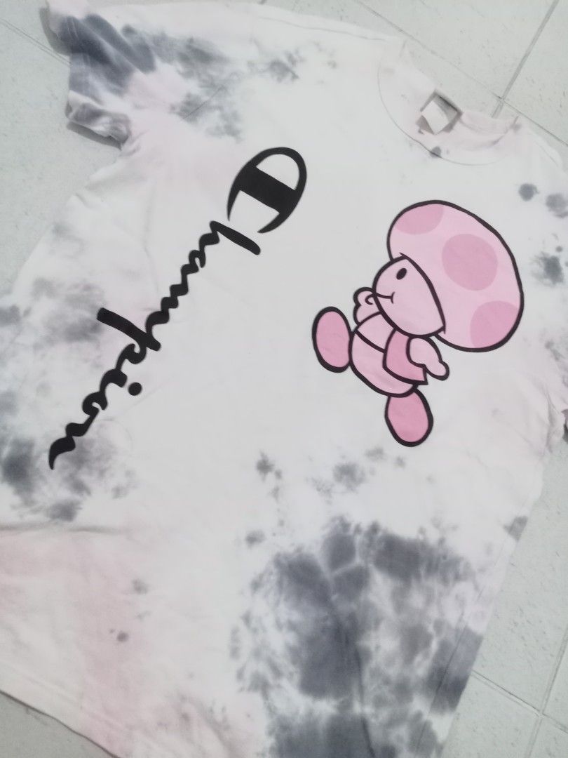 Champion Toadette Tie Dye T-Shirt (Category: Shirts) located in Manila. Submitted by kitkathrift (Listing ID 1465868290, Image 2). Description: - Brand: Champion - Character/Design: Toadette graphic with vertical script logo - Pattern/Color: Grey and white acid wash with pink accents - Size: Large - Material: 100% cotton - Origin: Made in Indonesia - Condition: Excellent, ready to wear.
