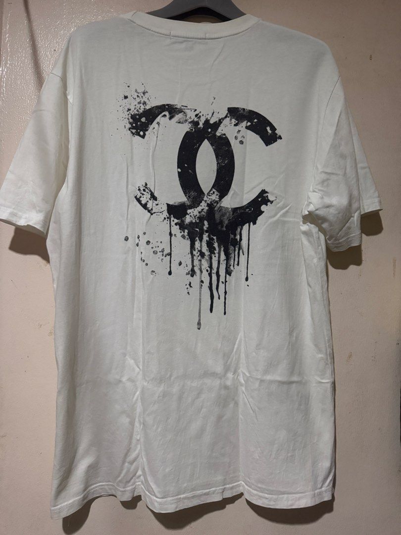 Channel Tee (Category: Tshirts & Polo Shirts ) located in Danao, Cebu. Submitted by welvirinec29053 (Listing ID 1465778874, Image 2). Description: The shirt features a stylized graphic caricature of the legendary fashion designer Karl Lagerfeld rendered as a skeleton skull wearing his iconic high-collared shirt, tie, sunglasses, and slicked-back hair layout. size xxl fit large dimes 21x28 color rate 9/10 .