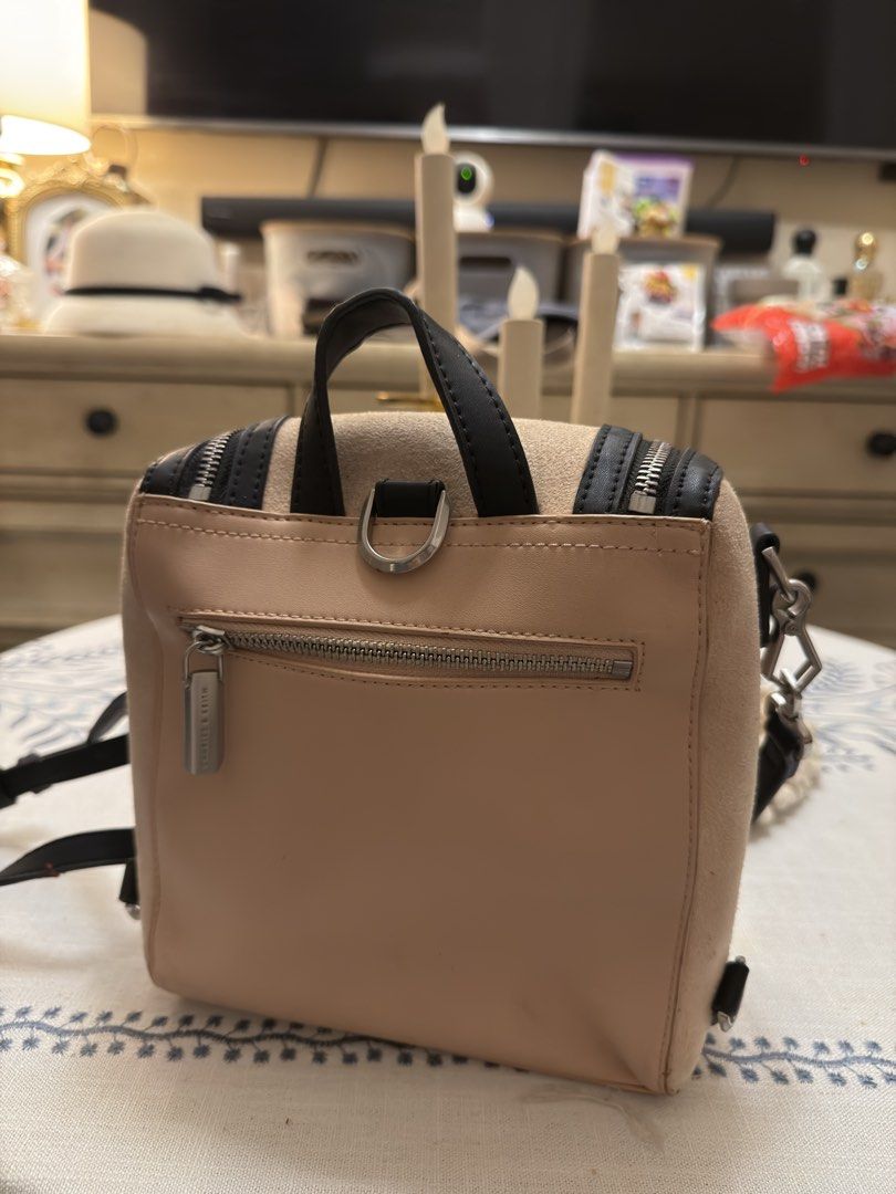 Charles & Keith Beige and Black Mini Backpack (Category: Backpacks) located in Quezon City. Submitted by cndcvrtc (Listing ID 1465944807, Image 2). Description: - Brand: Charles & Keith - Style: Mini backpack - Color/Material: Beige suede with black trim and silver hardware - Features: Dual vertical front zippers, back zippered pocket, top carry handle, and removable shoulder straps - Condition: Noticeable stains and discoloration on the suede fr