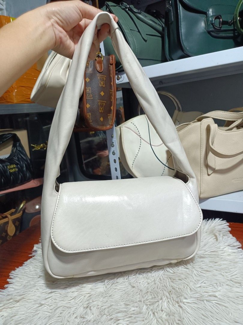 Charles & Keith White Shoulder Bag (Category: Shoulder Bags) located in Naga. Submitted by zksboutique (Listing ID 1465936045, Image 1). Description: - Brand: Charles & Keith - Color: Clean off-white (goes with everything) - Material: Soft faux leather - Closure: Front flap - Strap: Comfortable wide strap - Hardware: Silver brand lettering on the side - Size: Perfect everyday bag for phone, wallet, and keys.