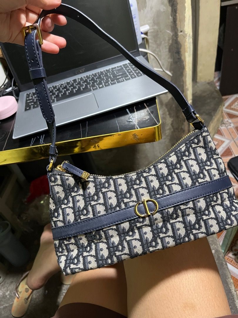 Christian Dior Oblique Saddle Pouch Blue (Category: Luxury Bags & Wallets) located in Rosario. Submitted by namayang_ (Listing ID 1465917135, Image 1). Description: -Christian Dior mini shoulder bag - Navy blue Oblique jacquard canvas with gold-tone hardware - Iconic CD logo plaque on the front - Adjustable leather strap for comfortable wear - Secure zip closure with branded zipper pull - Interior features leather patch "Christian Dior Paris Made