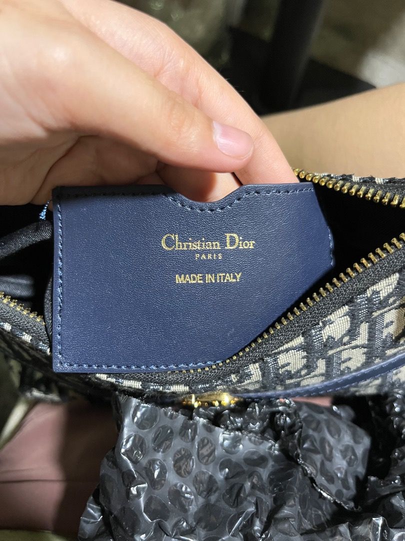 Christian Dior Oblique Saddle Pouch Blue (Category: Luxury Bags & Wallets) located in Rosario. Submitted by namayang_ (Listing ID 1465917135, Image 3). Description: -Christian Dior mini shoulder bag - Navy blue Oblique jacquard canvas with gold-tone hardware - Iconic CD logo plaque on the front - Adjustable leather strap for comfortable wear - Secure zip closure with branded zipper pull - Interior features leather patch "Christian Dior Paris Made