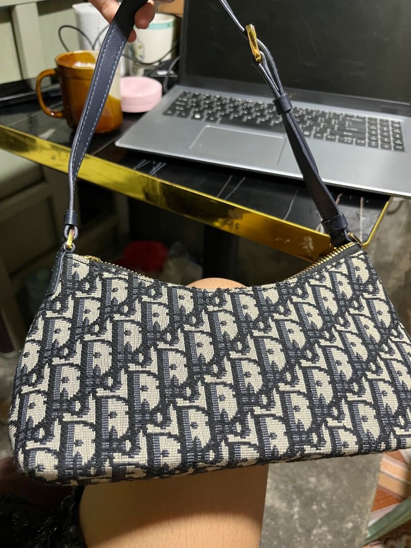 Christian Dior Oblique Saddle Pouch Blue (Category: Luxury Bags & Wallets) located in Rosario. Submitted by namayang_ (Listing ID 1465917135, Image 2). Description: -Christian Dior mini shoulder bag - Navy blue Oblique jacquard canvas with gold-tone hardware - Iconic CD logo plaque on the front - Adjustable leather strap for comfortable wear - Secure zip closure with branded zipper pull - Interior features leather patch "Christian Dior Paris Made