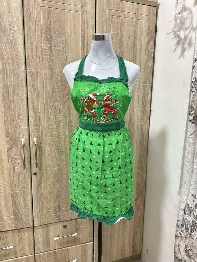Christmas Gingerbread Man Festive Kitchen Apron (Category: Coats, Jackets and Outerwear) located in Cavite. Submitted by cl09-39734 (Listing ID 1465818782, Image 2). Description: - Festive green holiday apron with adorable gingerbread couple graphic - Features 'Tis the Season text and an all-over pine tree and snowflake pattern - Charming ruffle trim along the top neckline and bottom hem - Adjustable halter neck tie design - Brand new and perfect