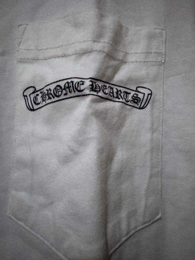 Chromehearts Pocket Tee (Category: Tshirts & Polo Shirts ) located in Danao, Cebu. Submitted by welvirinec29053 (Listing ID 1465781388, Image 3). Description: This appears to be a white Chrome Hearts Scroll Logo Pocket T-shirt featuring the iconic Gothic scroll lettering printed directly across the chest pocket. with back hit size M dimes 20x28 color 9/10.