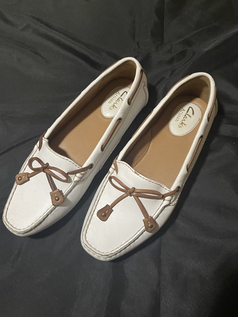 Clarks Artisan White Leather Moc Toe Loafers Drivers (Category: Loafers) located in Pateros City. Submitted by Saranghae (Listing ID 1465790624, Image 1). Description: ⏬️READ FIRST⏬️ - Brand: Clarks Artisan - Style: Slip-on driver loafers in white leather - Details: Brown bow accent, contrast stitching, debossed heel logo - Sole: Rubber grip pads on sole and heel for traction - Condition: Clean interiors with branded insoles - Versatility: Ideal 