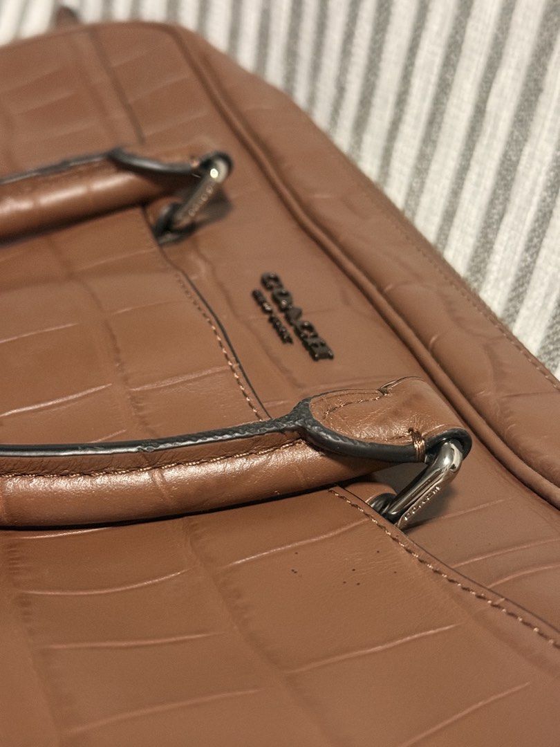 Coach Brown Crocodile Embossed Leather Briefcase Laptop Bag (Category: Luxury Bags & Wallets) located in Caloocan City. Submitted by kimterest (Listing ID 1465873335, Image 1). Description: - Brand/Model: Coach briefcase in brown crocodile embossed leather - Hardware: Dark gunmetal with Coach New York debossed logo - Strap: Includes detachable black and brown shoulder strap with swivel lobster clasps and matching leather hangtag - Condition: Clea