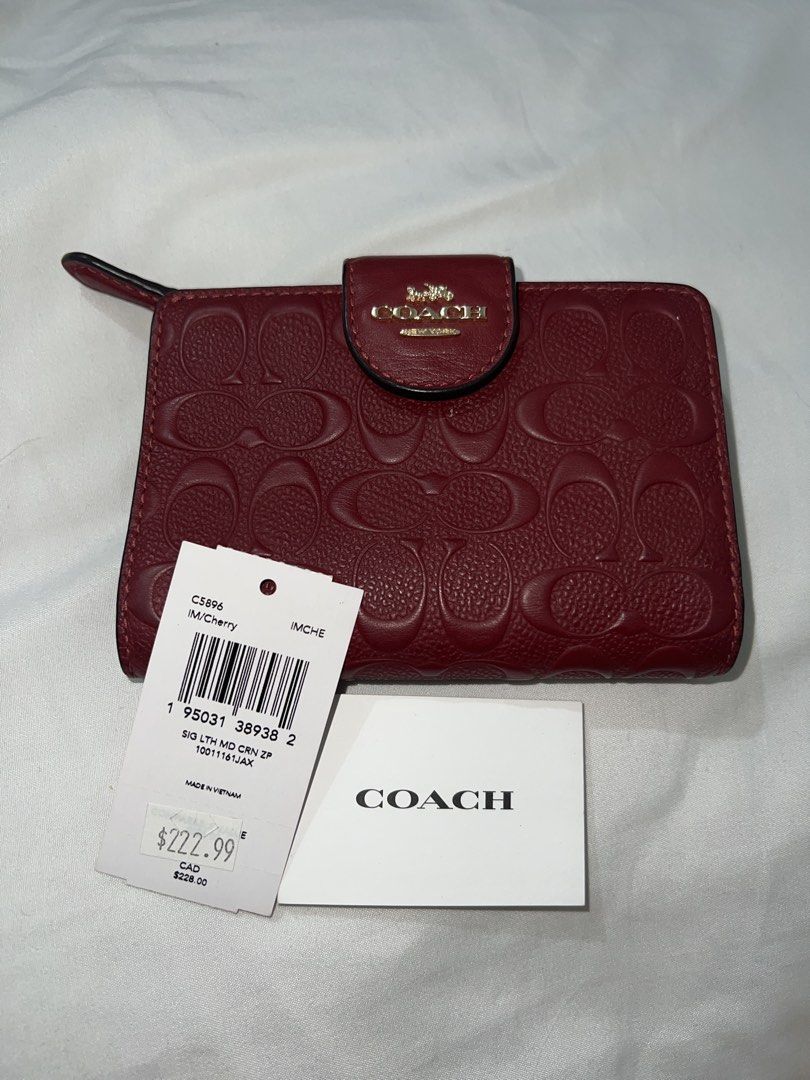 Coach Cherry Signature Leather Medium Corner Zip Wallet (Category: Wallets & Card holders) located in Marikina City. Submitted by ash_2 (Listing ID 1465880019, Image 1). Description: Coach wallet in IM/Cherry colorway. Signature debossed leather exterior with snap closure and gold-tone hardware. Interior contains multiple card slots, ID window, bill compartment, and a zip coin pocket. Complete with original tag showing $222.99 USD / $228.00 CAD a