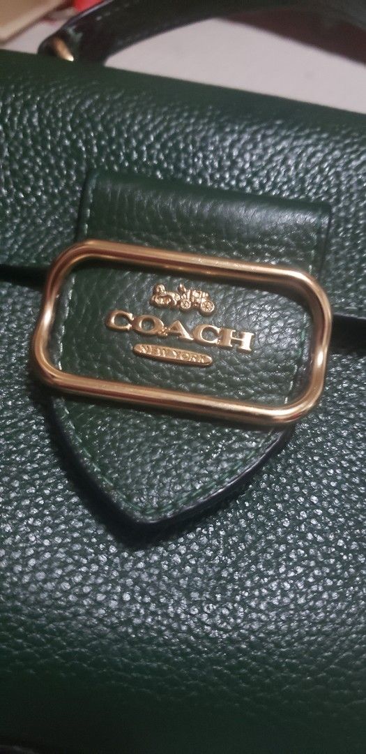 Coach Dark Green Leather Handbag (Category: Luxury Bags & Wallets) located in Marikina City. Submitted by racoon143 (Listing ID 1465936040, Image 2). Description: - Brand: Coach - Material: Dark green pebbled leather - Hardware: Gold-tone metal - Closure: Front flap with metal buckle - Handle: Single top handle - Extras: Matching green leather hangtag with embossed logo - Interior: Unlined brown suede finish on flap underside sign of usage..like 