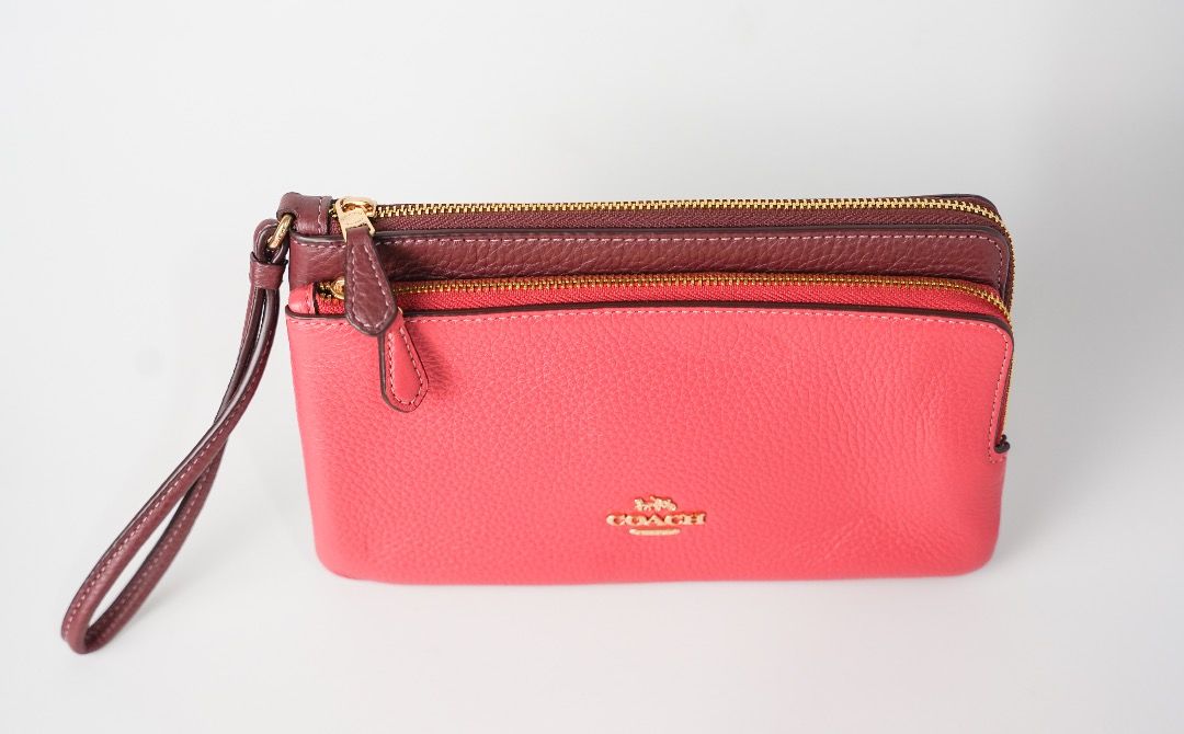 Coach Double Zip Wristlet Wallet Pink Maroon (Category: Wallets & Card holders) located in Pasig City. Submitted by laagn.ph (Listing ID 1465764474, Image 2). Description: - Authentic Coach double zip wristlet - Stylish two-tone bright pink and deep maroon pebbled leather - Elegant gold hardware with gold foil Coach logo - Dual zippered compartments with an extra middle slip pocket - Includes a matching attached wrist strap.