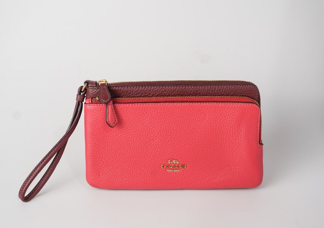 Coach Double Zip Wristlet Wallet Pink Maroon (Category: Wallets & Card holders) located in Pasig City. Submitted by laagn.ph (Listing ID 1465764474, Image 1). Description: - Authentic Coach double zip wristlet - Stylish two-tone bright pink and deep maroon pebbled leather - Elegant gold hardware with gold foil Coach logo - Dual zippered compartments with an extra middle slip pocket - Includes a matching attached wrist strap.