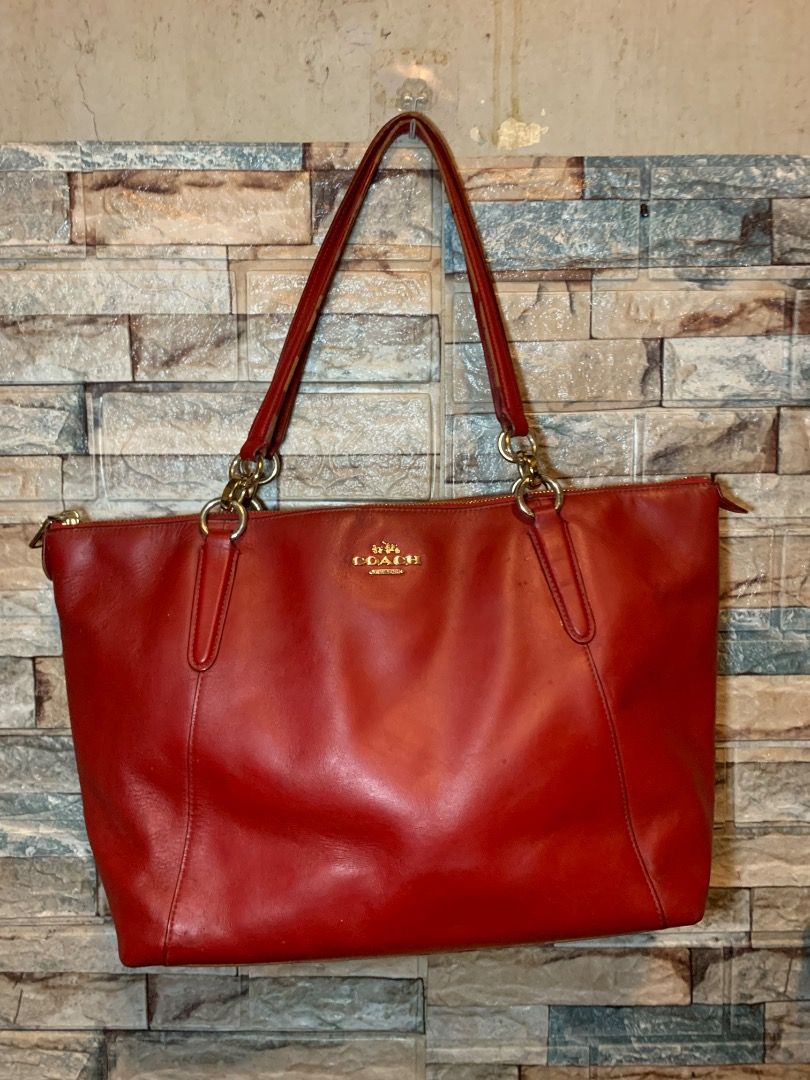 Coach Red Leather Tote Bag (Category: Tote Bags) located in Pasay City. Submitted by bhibeboutique (Listing ID 1465936502, Image 1). Description: - Brand: Coach - Material: Soft red leather with gold-tone hardware - Closure: Secure top zipper - Straps: Double shoulder straps with ring attachments - Design: Structured rectangular base and front gold logo lettering - Condition: Good overall, with some visible scuff marks on the base Pls manage your