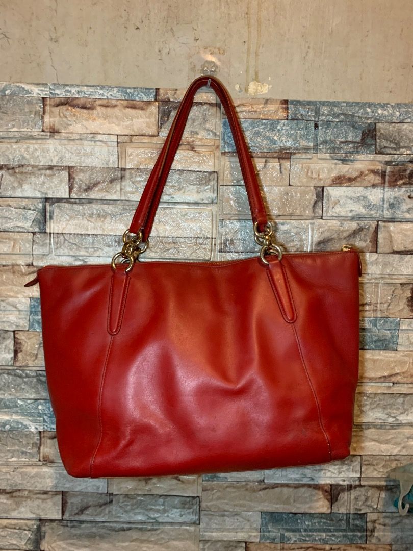Coach Red Leather Tote Bag (Category: Tote Bags) located in Pasay City. Submitted by bhibeboutique (Listing ID 1465936502, Image 2). Description: - Brand: Coach - Material: Soft red leather with gold-tone hardware - Closure: Secure top zipper - Straps: Double shoulder straps with ring attachments - Design: Structured rectangular base and front gold logo lettering - Condition: Good overall, with some visible scuff marks on the base Pls manage your