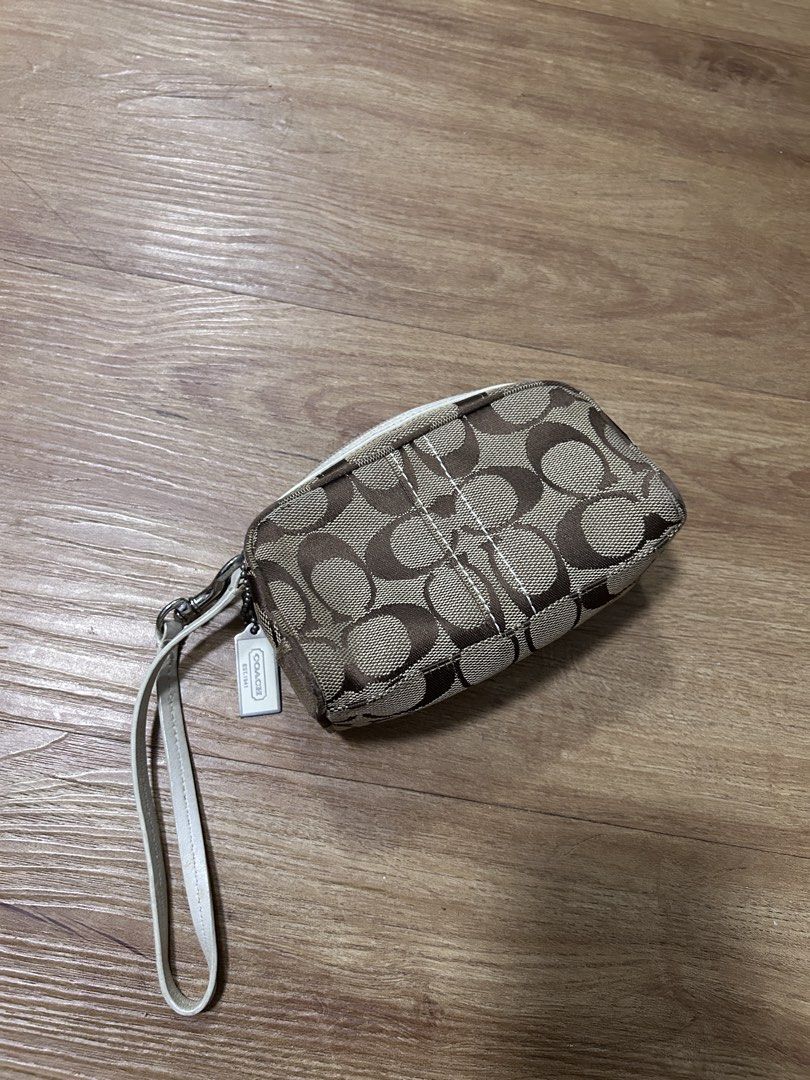 Coach Signature C Wristlet (Category: Luxury Bags & Wallets) located in Del Monte. Submitted by antonja (Listing ID 1465863455, Image 1). Description: - Brand: Coach - Design: Classic brown signature C monogram with chic white leather trim - Hardware: Polished silver-tone hardware with iconic Coach hangtag - Closure: Secure zip-top closure - Interior: Clean solid light purple fabric lining - Convenience: Includes matching white leather wrist stra